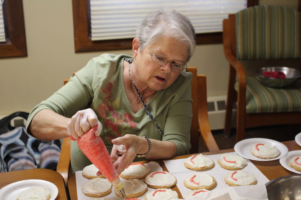 senior living resident decorates cookies