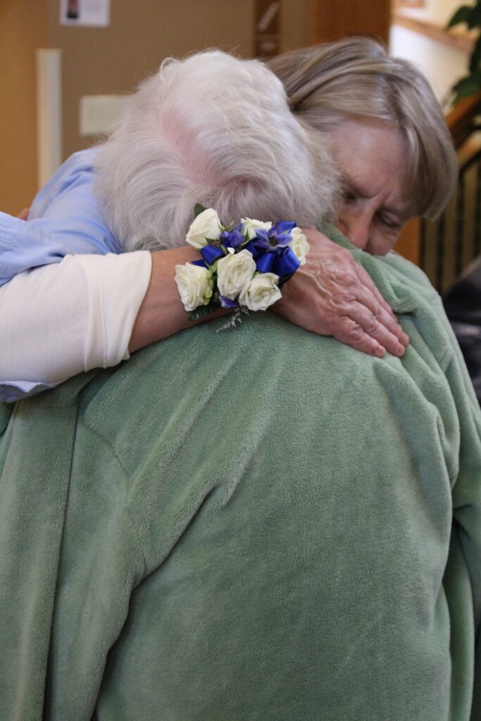senior living residents hugging