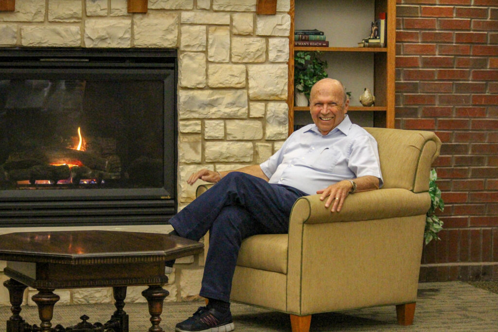 male senior living resident by fireplace