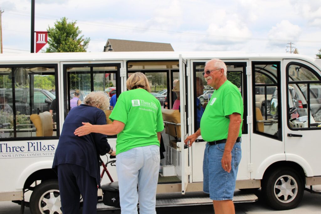 Volunteers at a Life Plan community help guests on the shuttle