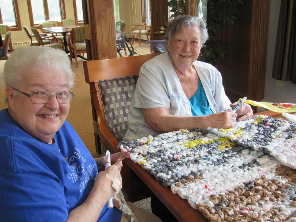 two senior living residents working on craft project for charity