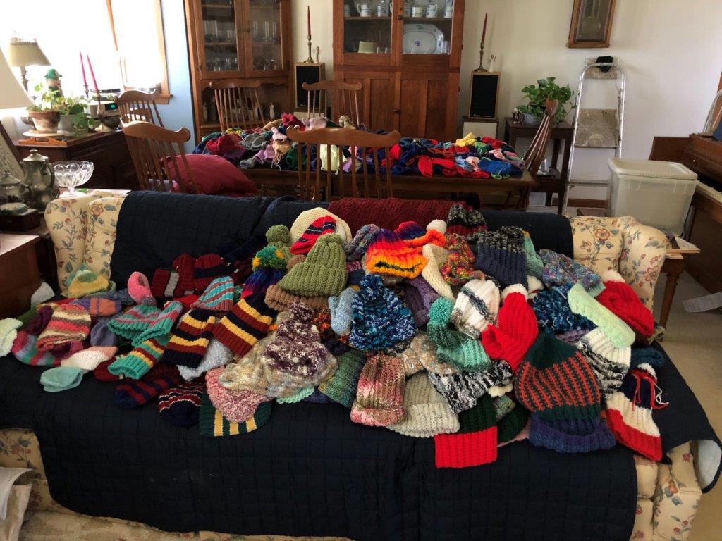 Pile of handmade winter clothing donated by Three Pillars residents