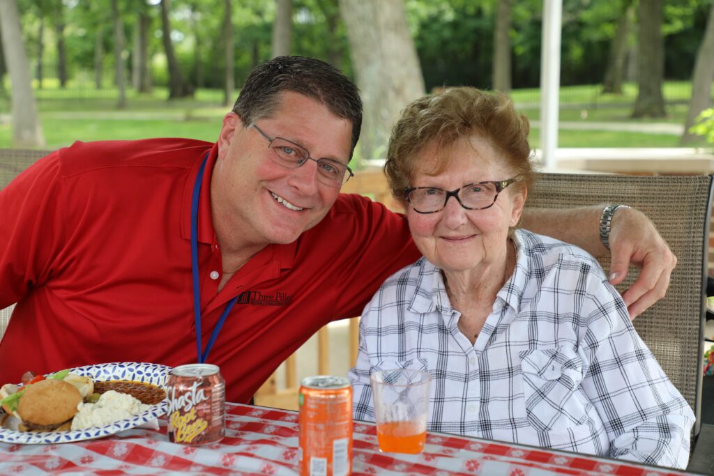 Nurse with elderly woman enjoyng lunch outdoors