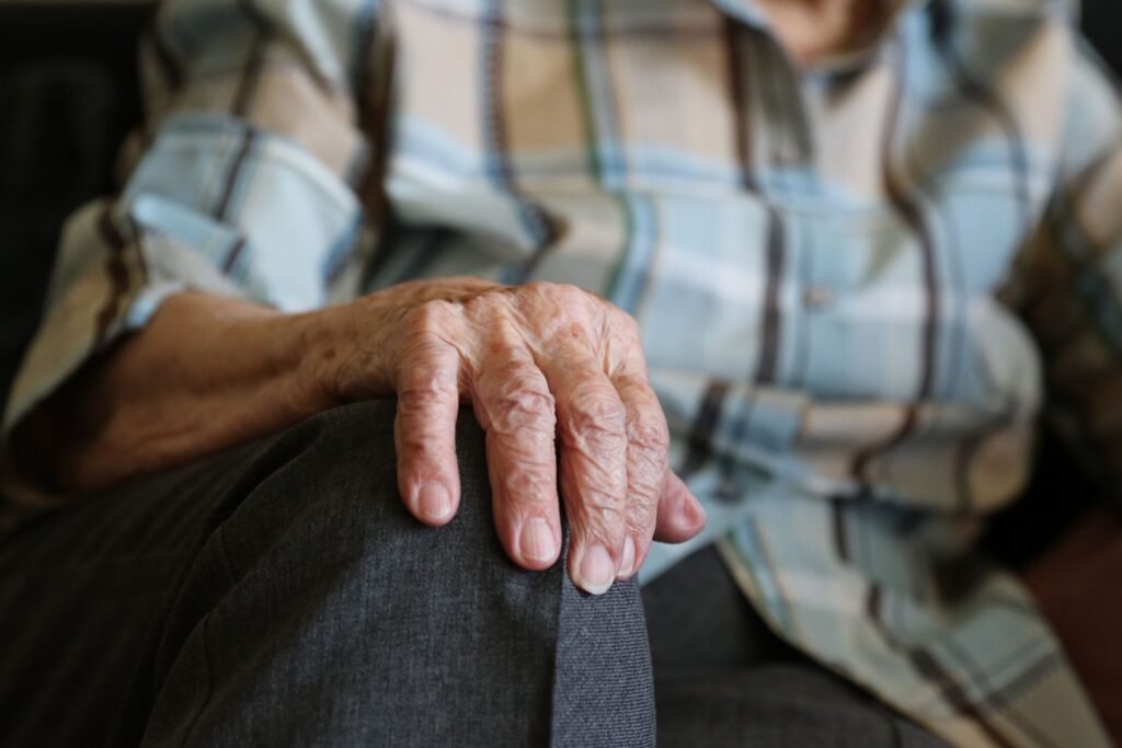 closeup with old woman's hand on her knee